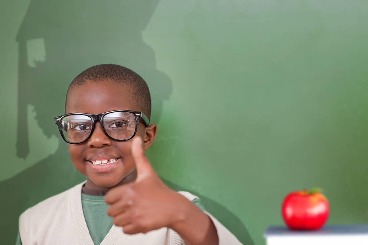 Young elementary school kid giving a thumbs up and his shadow showing an adult graduating