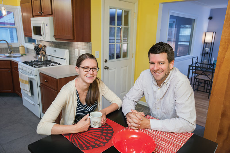 Young married couple sitting at table in their kitchen