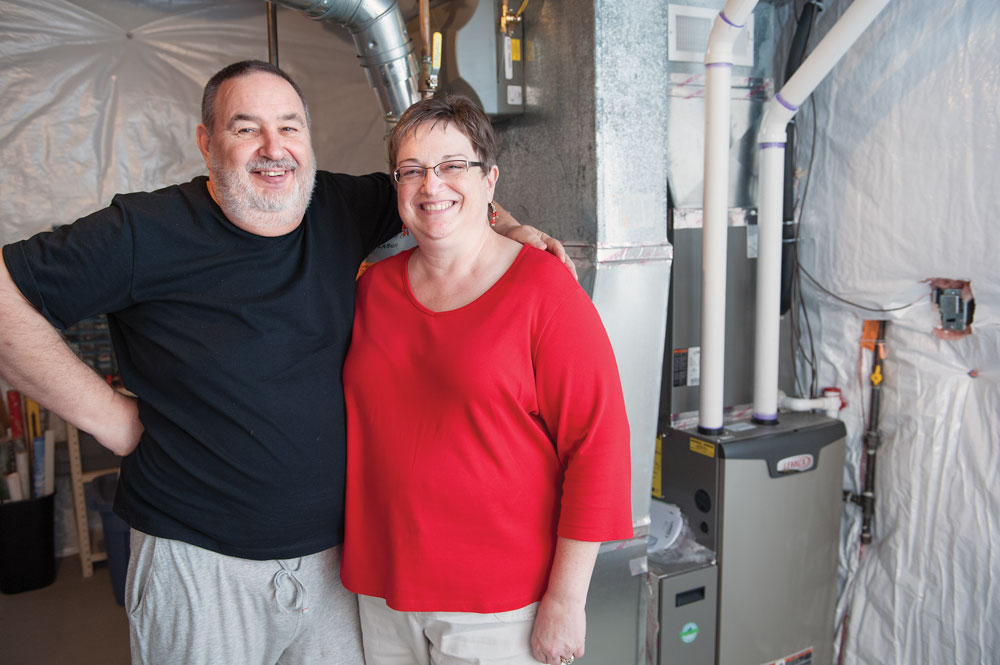The Peters stand in front of their upgraded energy-efficient furnace