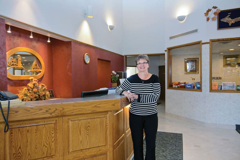 Woman standing behind the frontdesk of a hotel