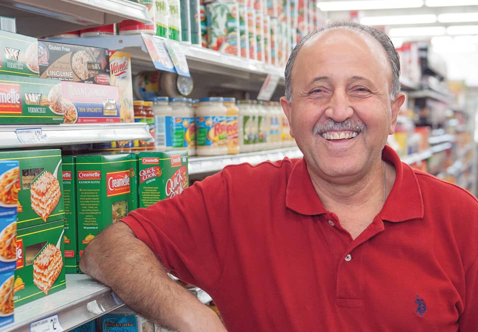 man leaning against a grocery store aisle shelf