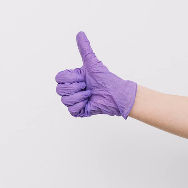 Hand wearing a glove giving a thumbs up