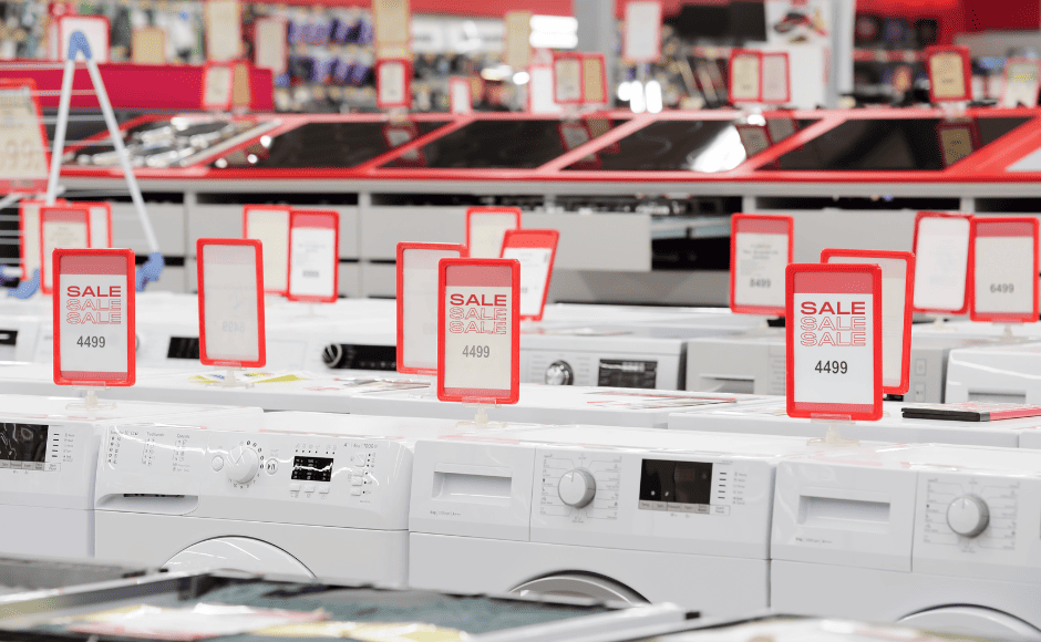 Row of washing machines in a store with red "Sale" signs